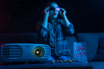 Cheerful viewing of a girl in 3D glasses at a home cinema. Rest and relaxation