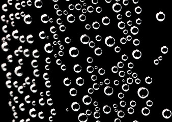 Air balls in water on a black background