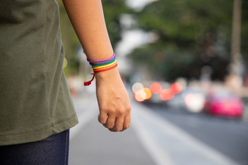 confident LGBT woman showing rainbow ribbon symbol; concept of LGBT pride, LGBTQ people, lgbt...