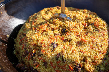 Rice pilaf in a cauldron at the stake