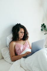 woman with laptop in bed freelancer