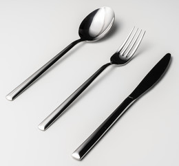Spoon, fork and knife on a white background