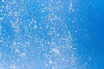 Obraz premium Splashing water from a fountain on a background of blue sky
