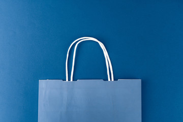 Blue shopping bag on blue background, top view