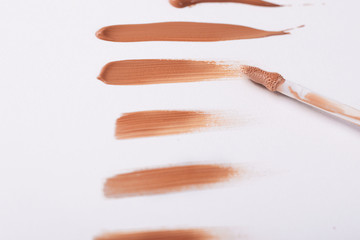 Smear foundation on a white background. Drop concealer.