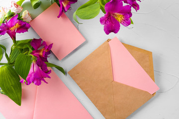 Top view of a pink paper letter and flowers with copy space