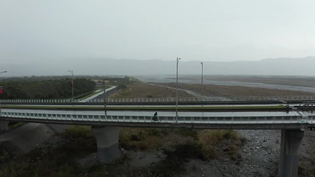 Aerial drone shot of biker on a bridge in Taiwan