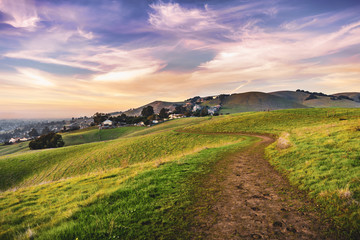 Sunset view of hiking trail on the verdant hills of East San Francisco Bay Area; California