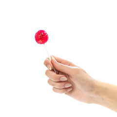 The hand holds a red round Lollipop on a stick. Close up. Isolated on a white background