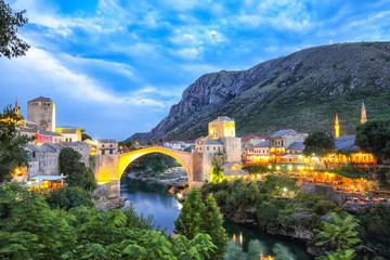 Fototapeta premium Majestic evening view of Mostar with the Mostar Bridge, houses and minarets, at evening
