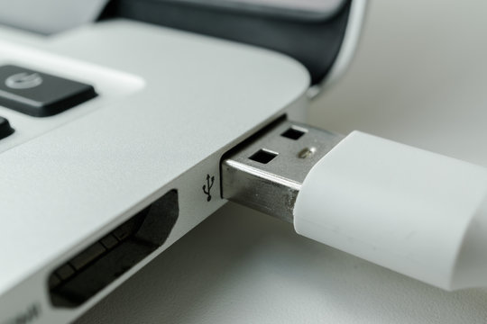 White USB cable connected to the laptop port