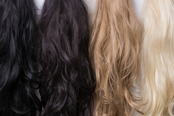Women's wigs of different shades. Blonde brunette brown-haired woman.