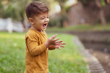 happy young boy playing outdoors in the park
