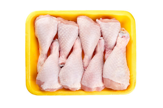 Chicken shin in yellow tray isolated on white background, top view. Raw poultry meat