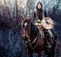 young dreadded girl with her horse and shamanic frame drum.