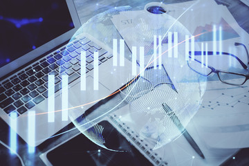 Stock market graph on background with desk and personal computer. Multi exposure. Concept of...