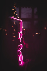 Gradient background. Neon lighting bright glowing. Glass tube and bulbs. Warm lights. Girl with lights in the mirror.