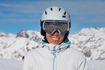 Portrait of a young pretty woman in a ski suit and helmet