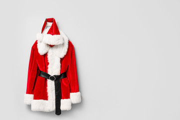 Santa Claus costume hanging on light wall