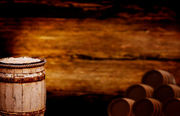 Whiskey barrel stands in a dark cellar with lots of wooden barrels, copy space