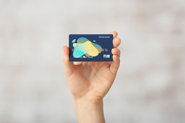 Female hand with credit card on light background
