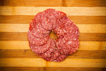 salami or sausage meat slices placed in a circle on cutting board