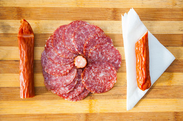 salami with sausage meat slices and napkin on cutting board