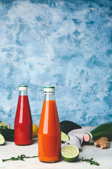 Bottles of fresh vegetable juices on white table
