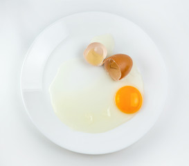 Broken eggs on a plate white background. reddish yellow
