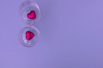 Red hearts shaped chocolates on the  blue background. Greeting card Happy Valentines Day. Copy space. Top view.