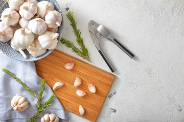 Fresh garlic with herbs and crusher on white background
