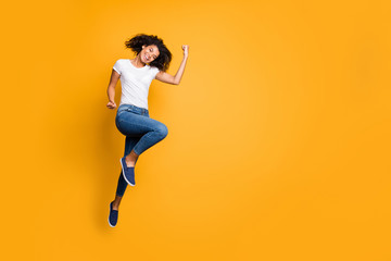 Fototapeta na wymiar Full length body size photo of cheerful positive curly wavy nice charming girl rejoicing about her team winning the competitions wearing jeans denim white t-shirt isolated vivid color background