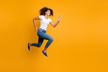Fototapeta na wymiar Full length body size view of her she nice attractive lovely cheerful purposeful wavy-haired girl jumping running motivation isolated over bright vivid shine vibrant yellow color background