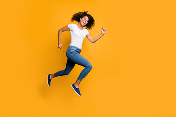 Fototapeta na wymiar Full length body size photo of cheerful charming cute nice quick millennnial wearing jeans denim white t-shirt footwear running jumping to shopping mall isolated vivid color background