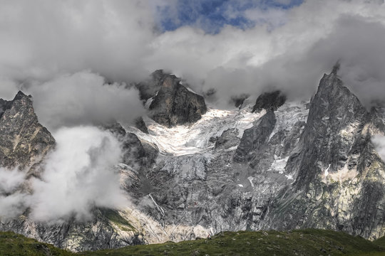 Les Grandes Jorasses partially hidden by clouds, from the grassy hill at the entrance to the Vallon de Malatrà, val ferret, Courmayeur, Aosta valley, Italy, Europe
