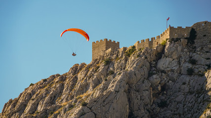 Paraglider flies past the walls of the medieval pirate fortress Stari Grad, Croatia