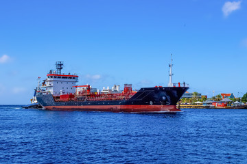 Fototapeta premium Tanker ship entering Willemstad , Konigin Juliana Bridge in the background Curacao
