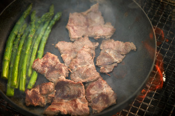 Cooking beef with asparagus on frying pan 