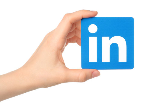 KIEV, UKRAINE - MARCH 7, 2015:Hand Holds Linkedin Logo Sign Printed On Paper On White Background. Linkedin Is A Business Social Networking Service.