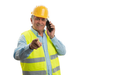 Builder talking on phone and pointing at camera