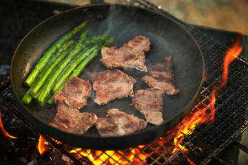 Cooking beef with asparagus on frying pan 