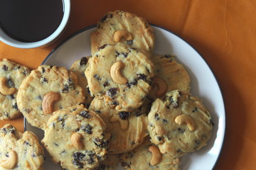 Pile of Delicious Chocolate Chip Cookies on a White Plate with coffee breakfast