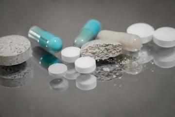 Assorted pills on grey background