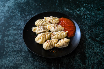 Georgian Dumplings Khinkali with Meat, Tomato Sauce and Spices / Hingel.