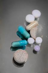 Assorted pills on grey background