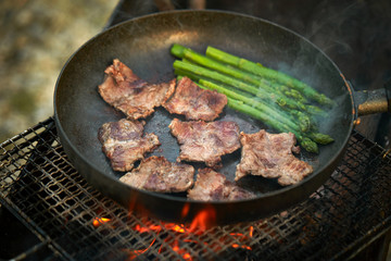 Cooking beef with asparagus on frying pan 