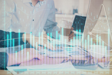 Multi exposure of chart with man typing on computer in office on background. Concept of hard work.