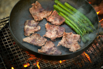 Cooking beef with asparagus on frying pan 