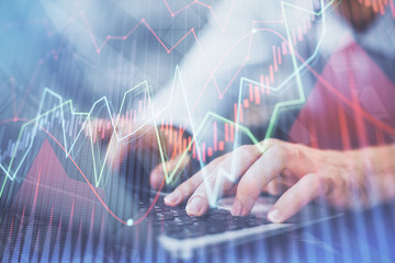 Forex graph with businessman typing on computer in office on background. Concept of analysis. Double exposure.