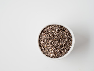 Chia seeds isolated on white background in the plate.